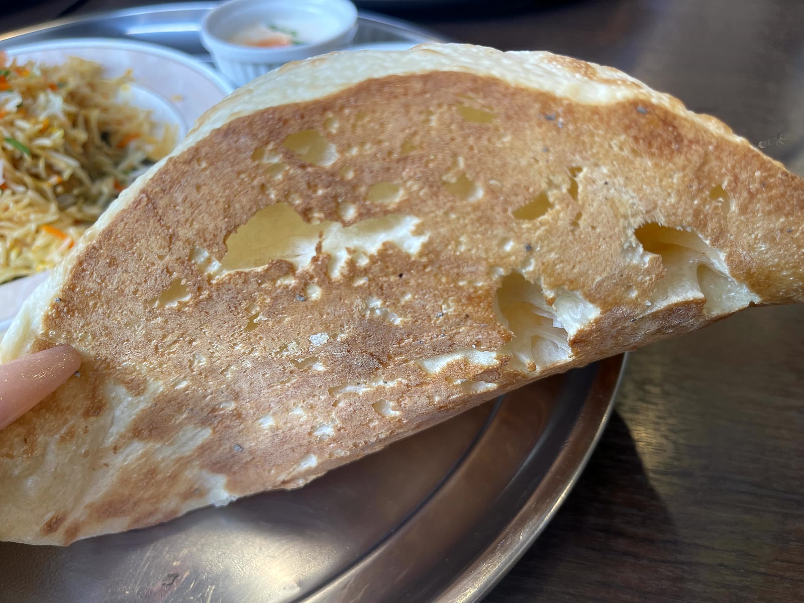 焼きたてのナンをアップで撮影。表面はこんがり、ところどころ生地が膨らんで香ばしく焼けている