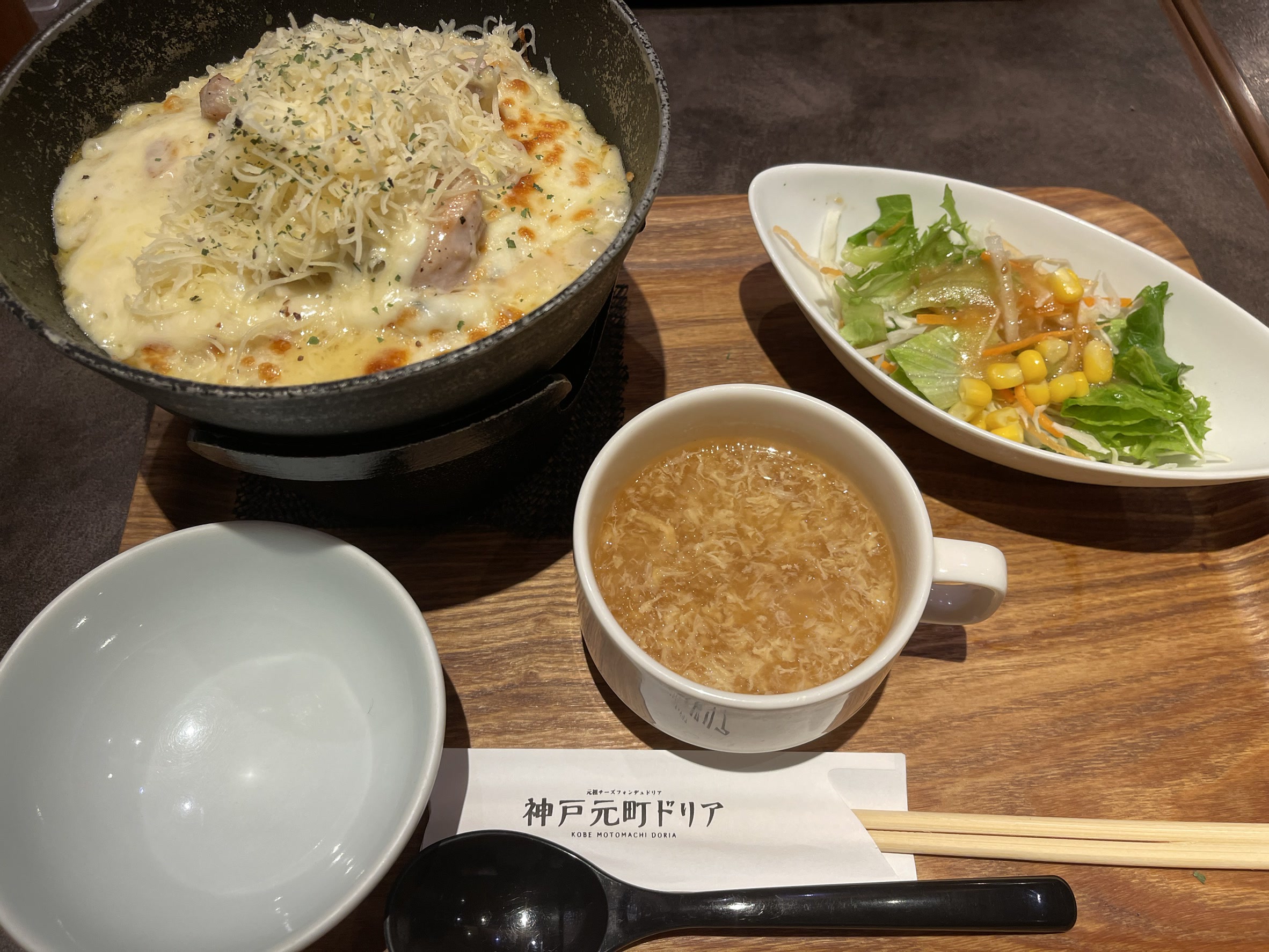 シーフードドリアのアップ。表面いっぱいに大量のシュレッドチーズがのり、こんがりと焼き色がつき、下からごろごろとした具材がのぞいている