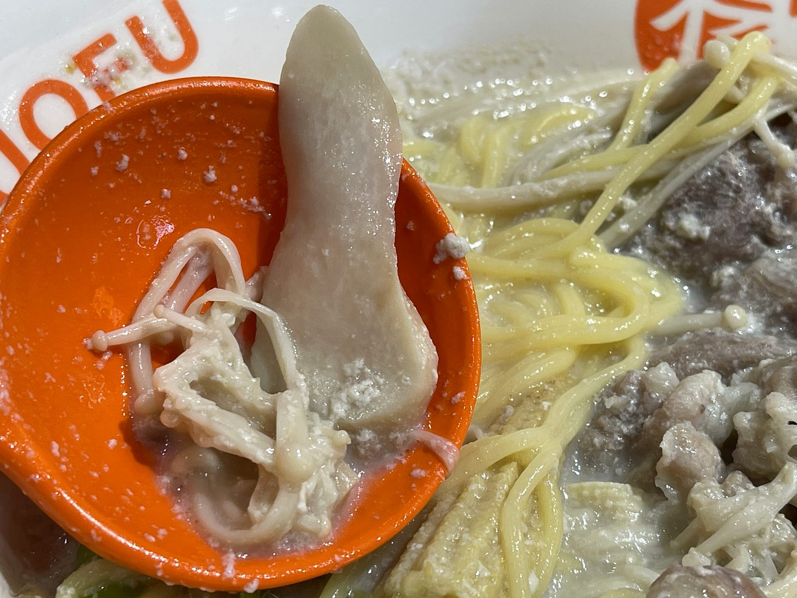 レンゲに乗せた細いえのきのクローズアップ