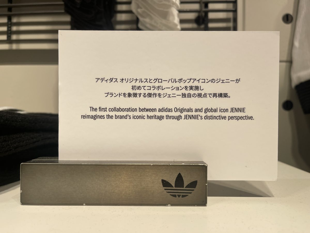 「アディダス オリジナルスとグローバルポップアイコンのジェニーが初めてコラボレーションを実施」と書かれた展示説明カード