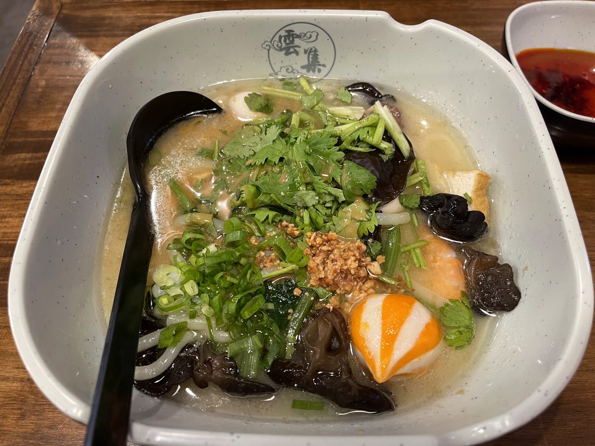 青菜ニンニクネギきくらげ湯葉などが入った鶏白湯スープ